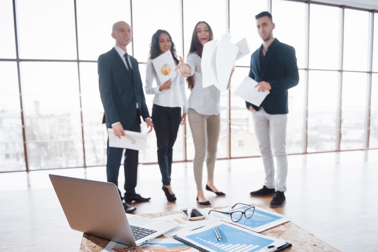 Pracownicy w biurze rzucający dokumenty.