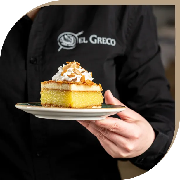 Dolce tradizionale tipico la torta El Greco con panna e mandorle tostate del Ristorante El Greco di Bologna, servito dal personale del locale.