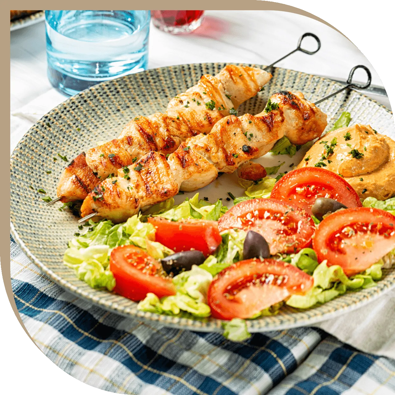 Souvlaki di pollo del Ristorante El Greco di Bologna con insalata greca e salsa fatta in casa.