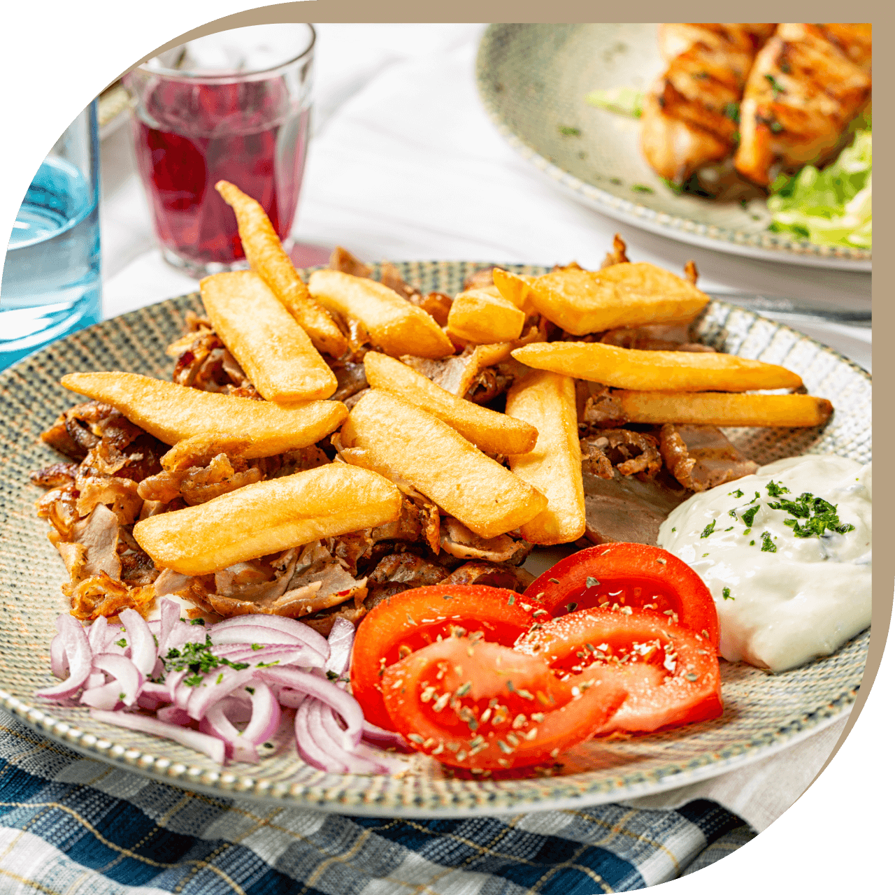 Gyros di carne del Ristorante El Greco di Bologna con patatine, pomodori e salsa tzatziki.