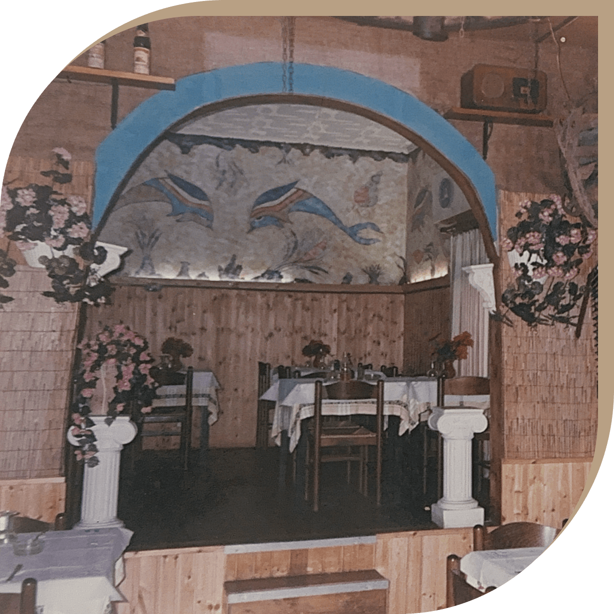 Storica sala del Ristorante El Greco di Bologna con affresco di delfini e arredamento tradizionale.