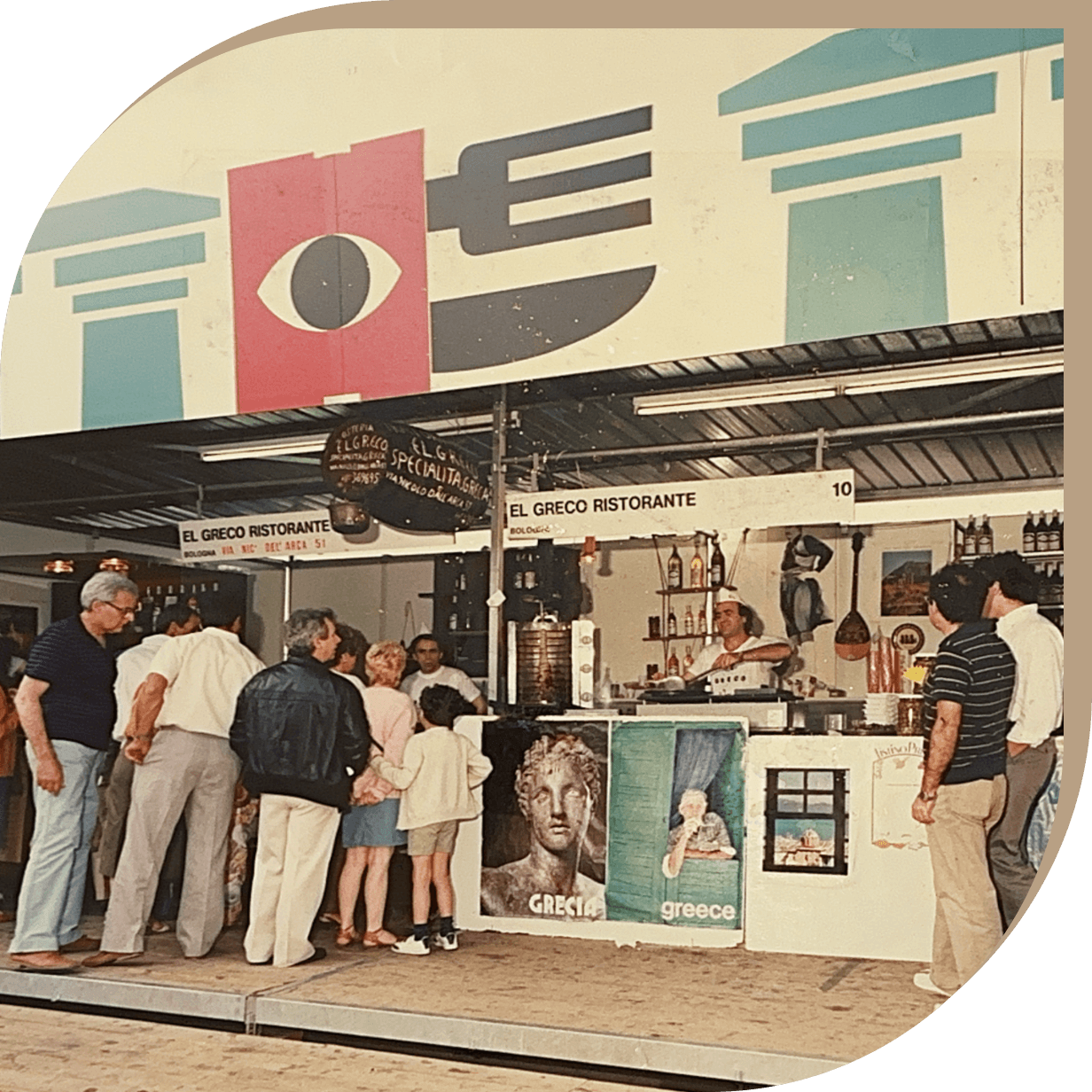 Stand del Ristorante El Greco alla Fiera di Bologna con il fondatore che serve piatti greci.