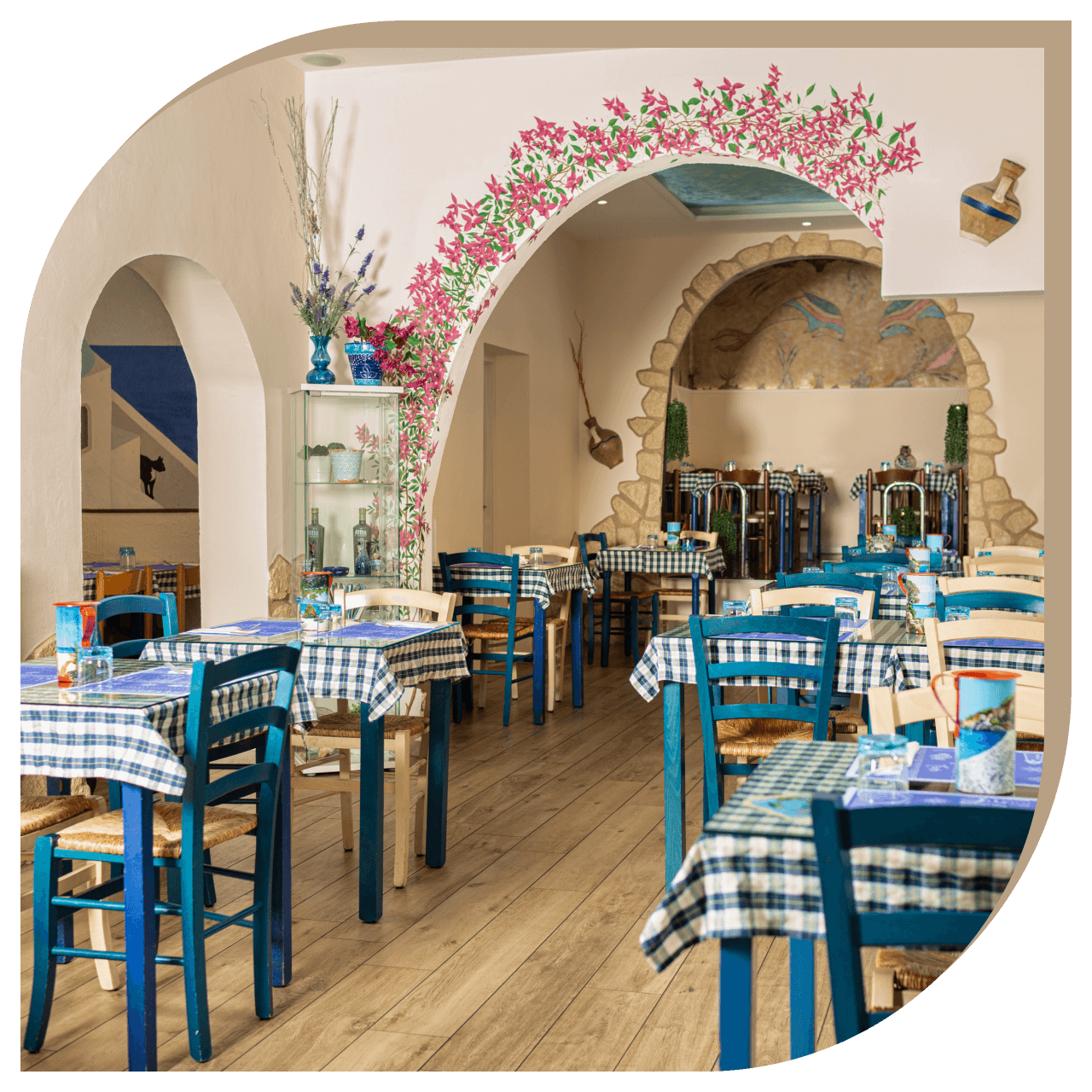 Interno del Ristorante El Greco di Bologna con tavoli apparecchiati e decorazioni in stile greco.