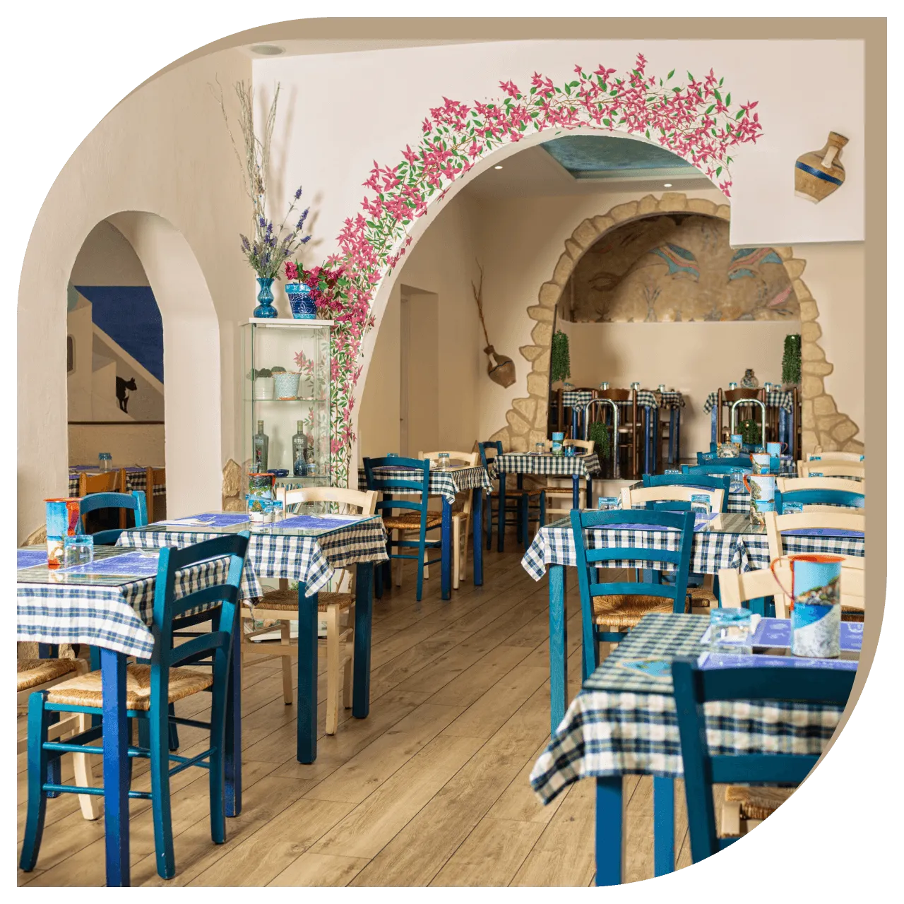 Interno del Ristorante El Greco di Bologna con tavoli apparecchiati e decorazioni in stile greco.