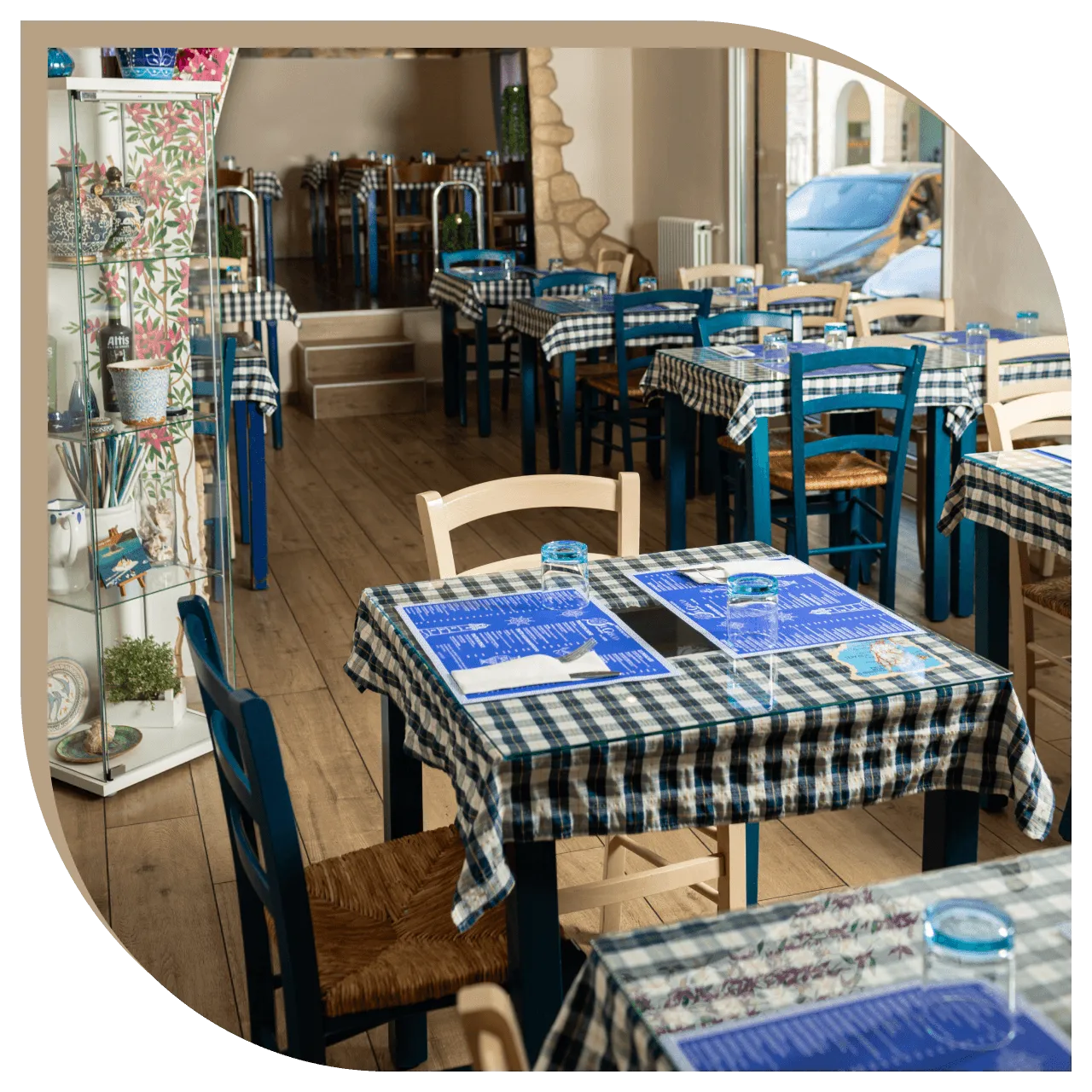 Dettaglio dei tavoli del Ristorante El Greco di Bologna con vaso greco e affresco dei delfini sullo sfondo.