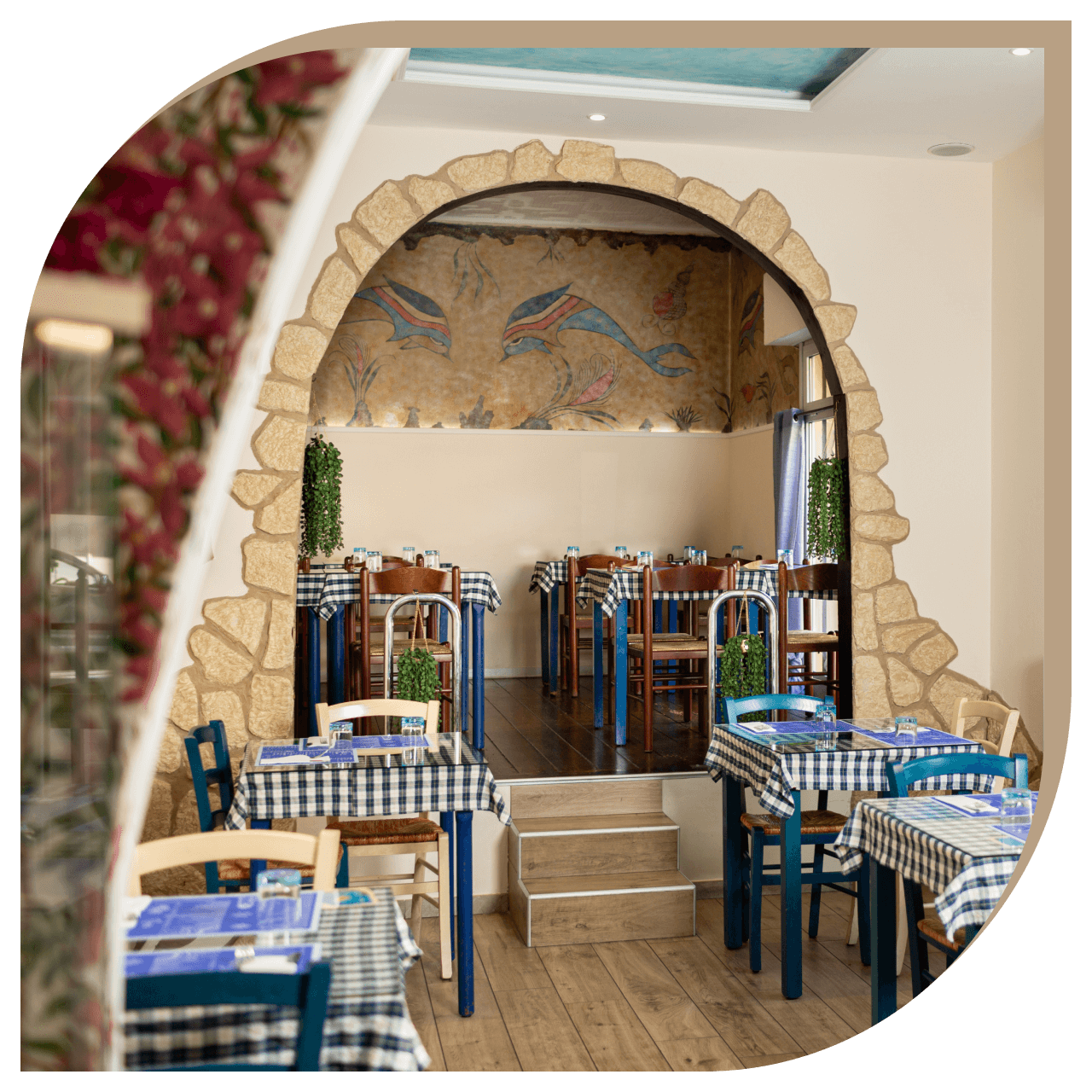 Zona rialzata del Ristorante El Greco di Bologna con affresco dei delfini e arredi tradizionali.