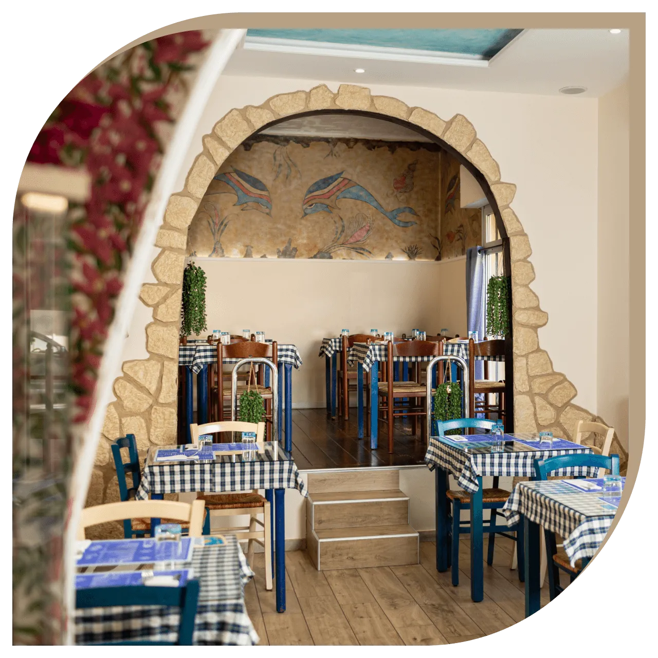 Zona rialzata del Ristorante El Greco di Bologna con affresco dei delfini e arredi tradizionali.