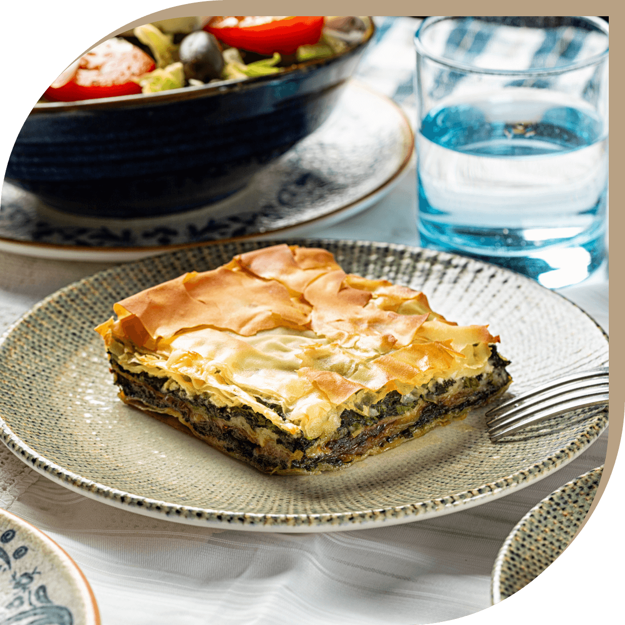 Spanakopita del Ristorante El Greco di Bologna, torta salata con spinaci e feta avvolta in pasta fillo croccante.