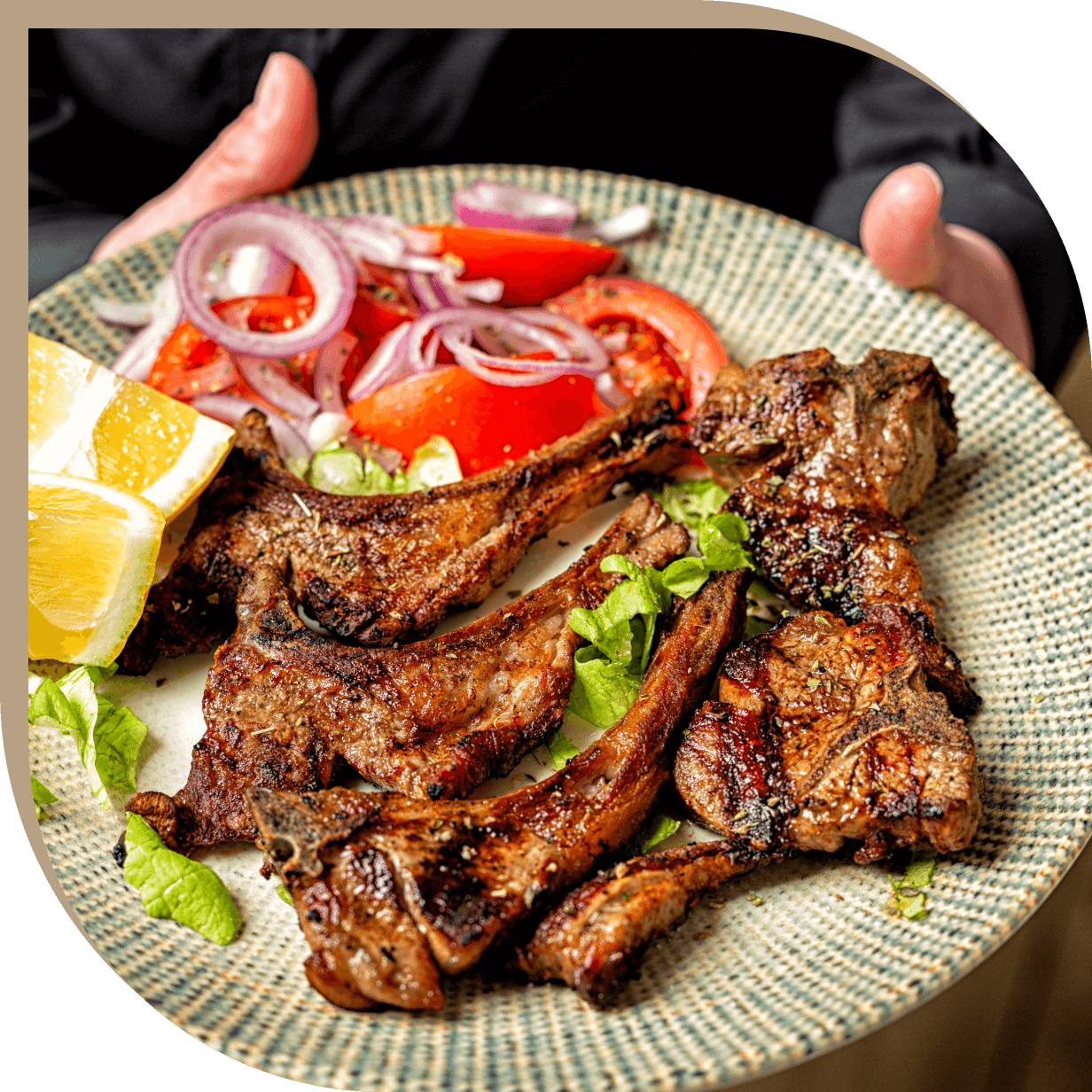 Costolette di agnello alla griglia con insalata fresca di pomodori e cipolla del Ristorante El Greco di Bologna.