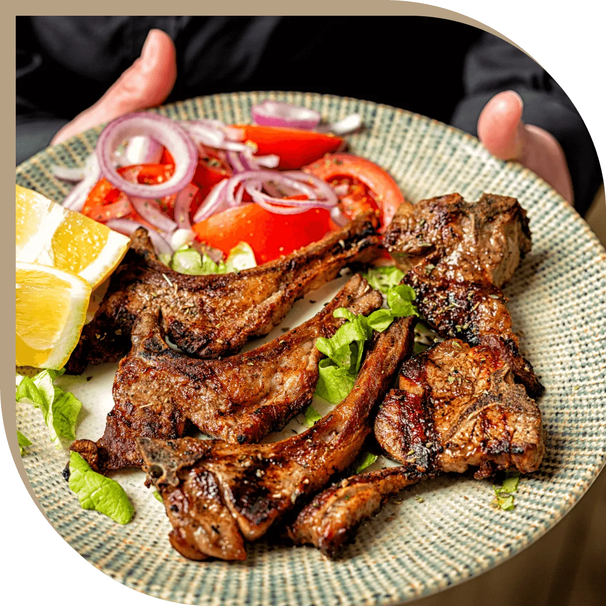 Costolette di agnello alla griglia con insalata fresca di pomodori e cipolla del Ristorante El Greco di Bologna.