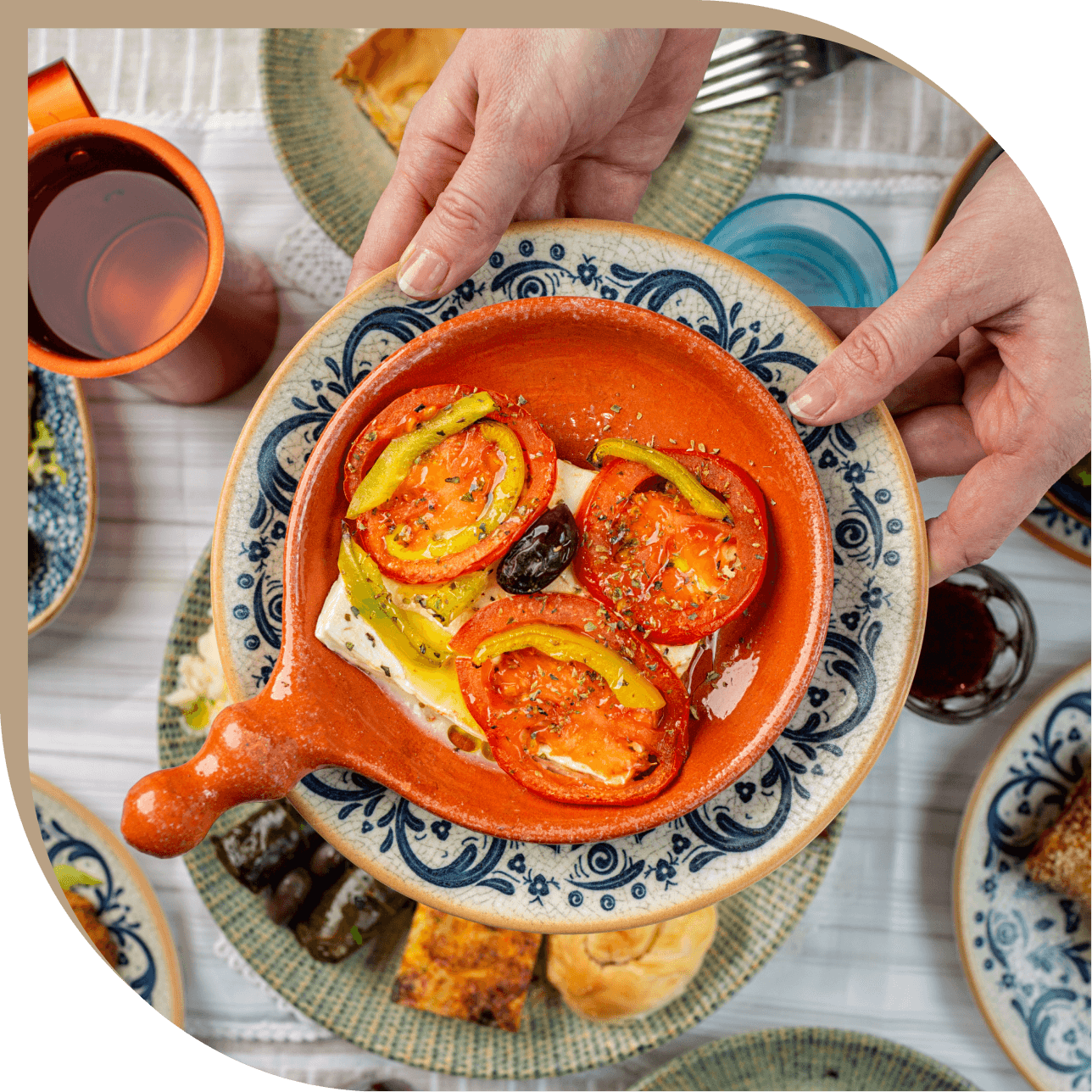 Feta al forno con pomodori, peperoni e olive nere servita in terracotta al Ristorante El Greco di Bologna.