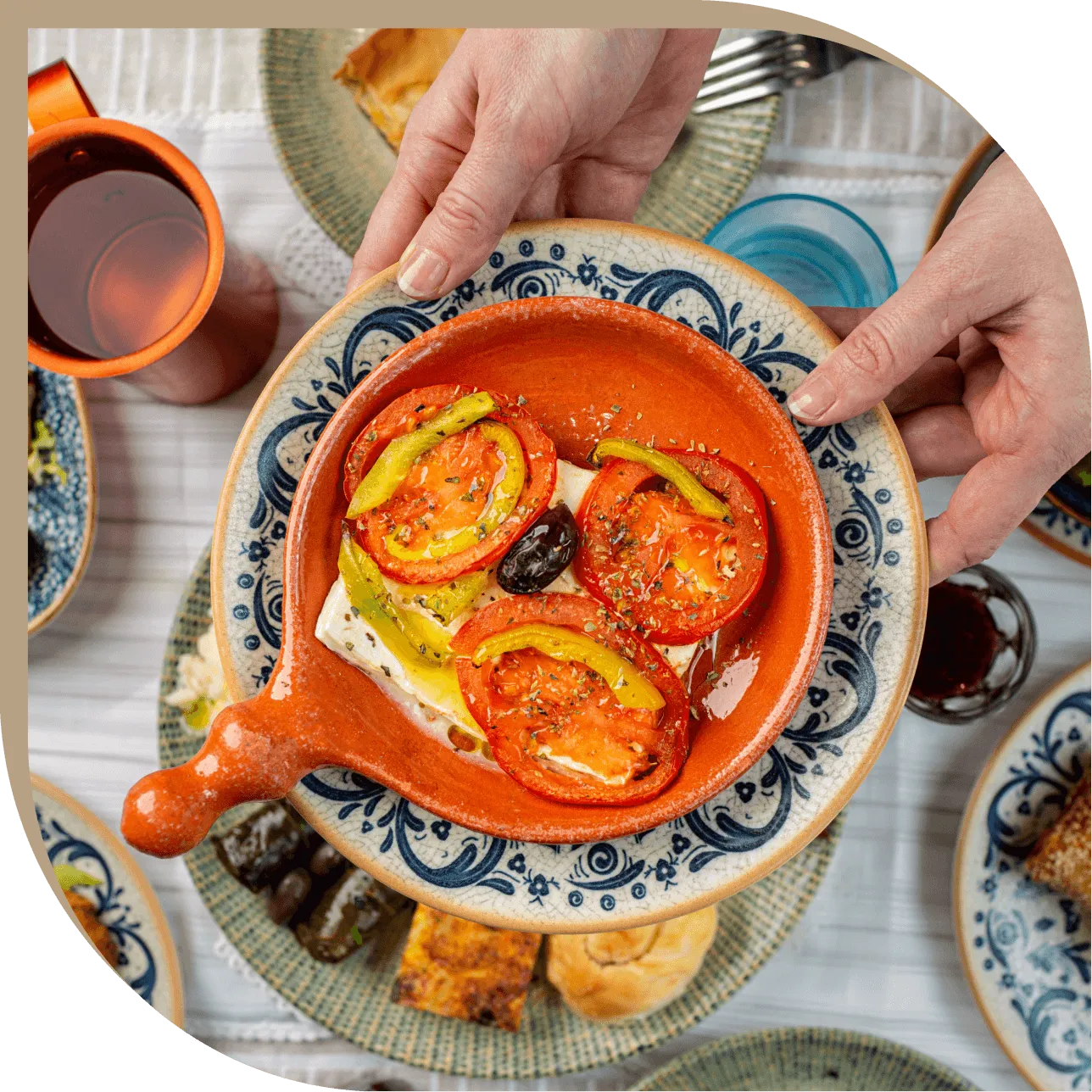 Feta al forno con pomodori, peperoni e olive nere servita in terracotta al Ristorante El Greco di Bologna.