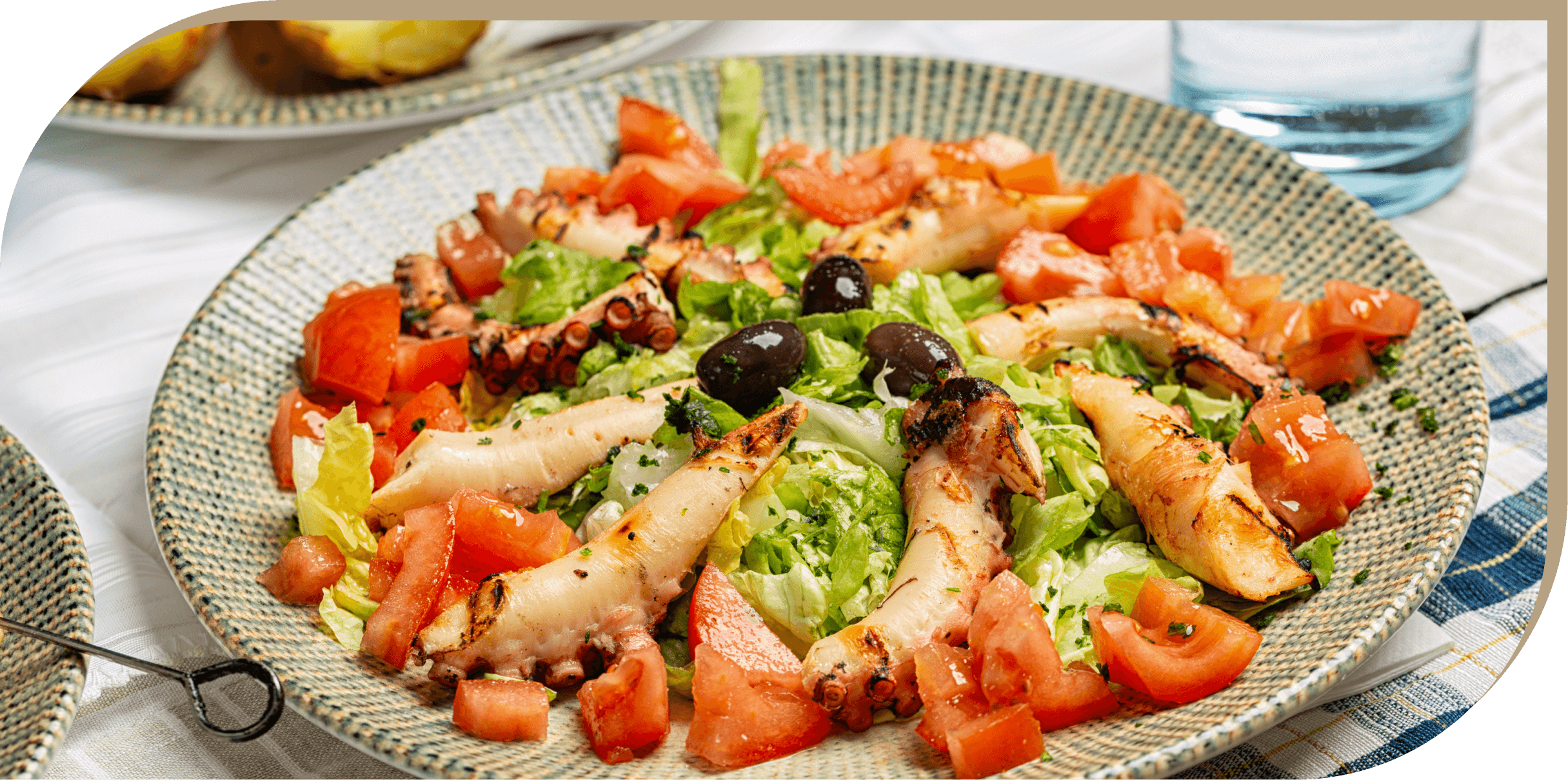 Polipo alla griglia con contorno di insalata, pomodori, olive e lattuga fresca del Ristorante El Greco di Bologna.