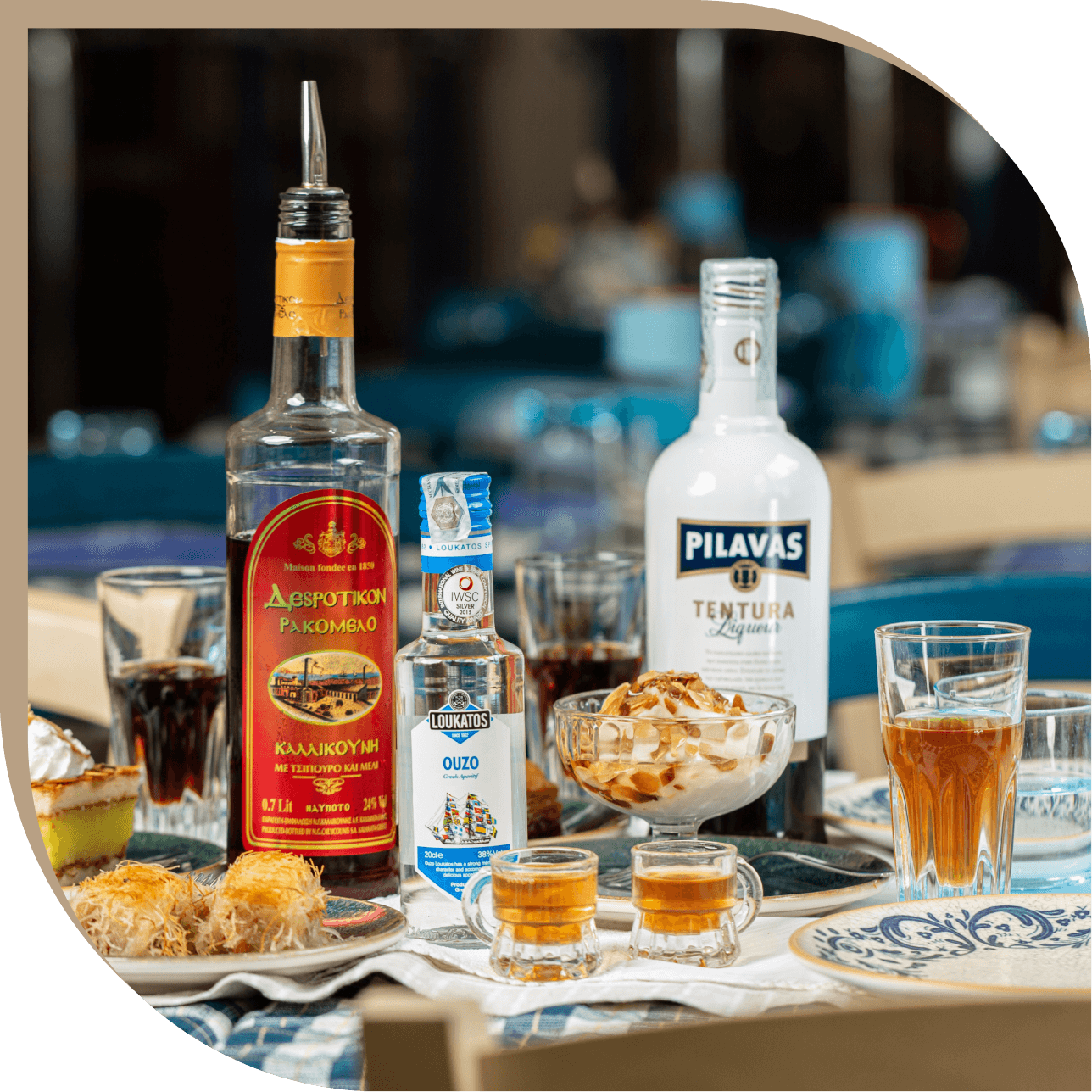 Selezione di liquori greci del Ristorante El Greco di Bologna, tra cui ouzo, tentura e rakomelo serviti con dolci della casa.