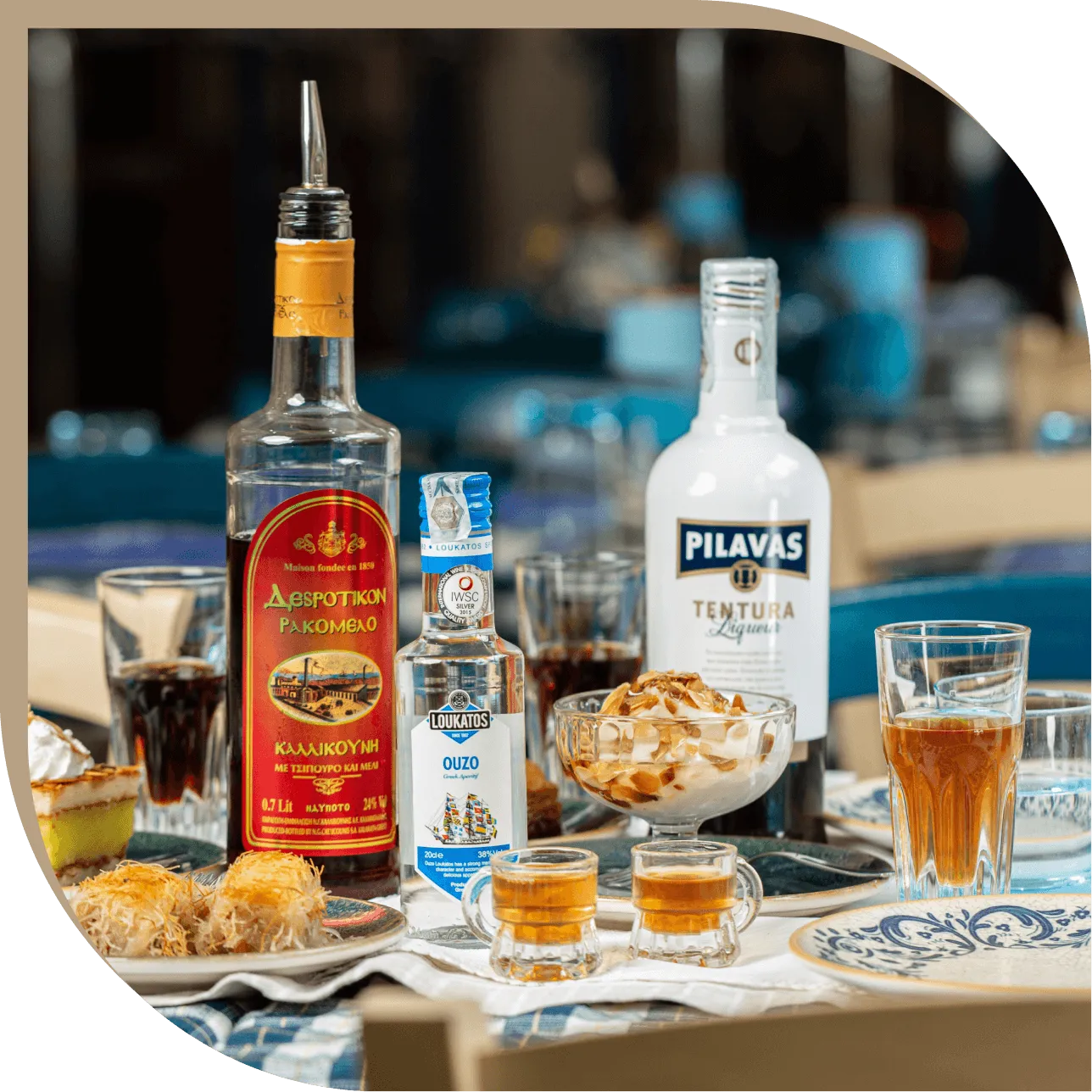 Selezione di liquori greci del Ristorante El Greco di Bologna, tra cui ouzo, tentura e rakomelo serviti con dolci della casa.