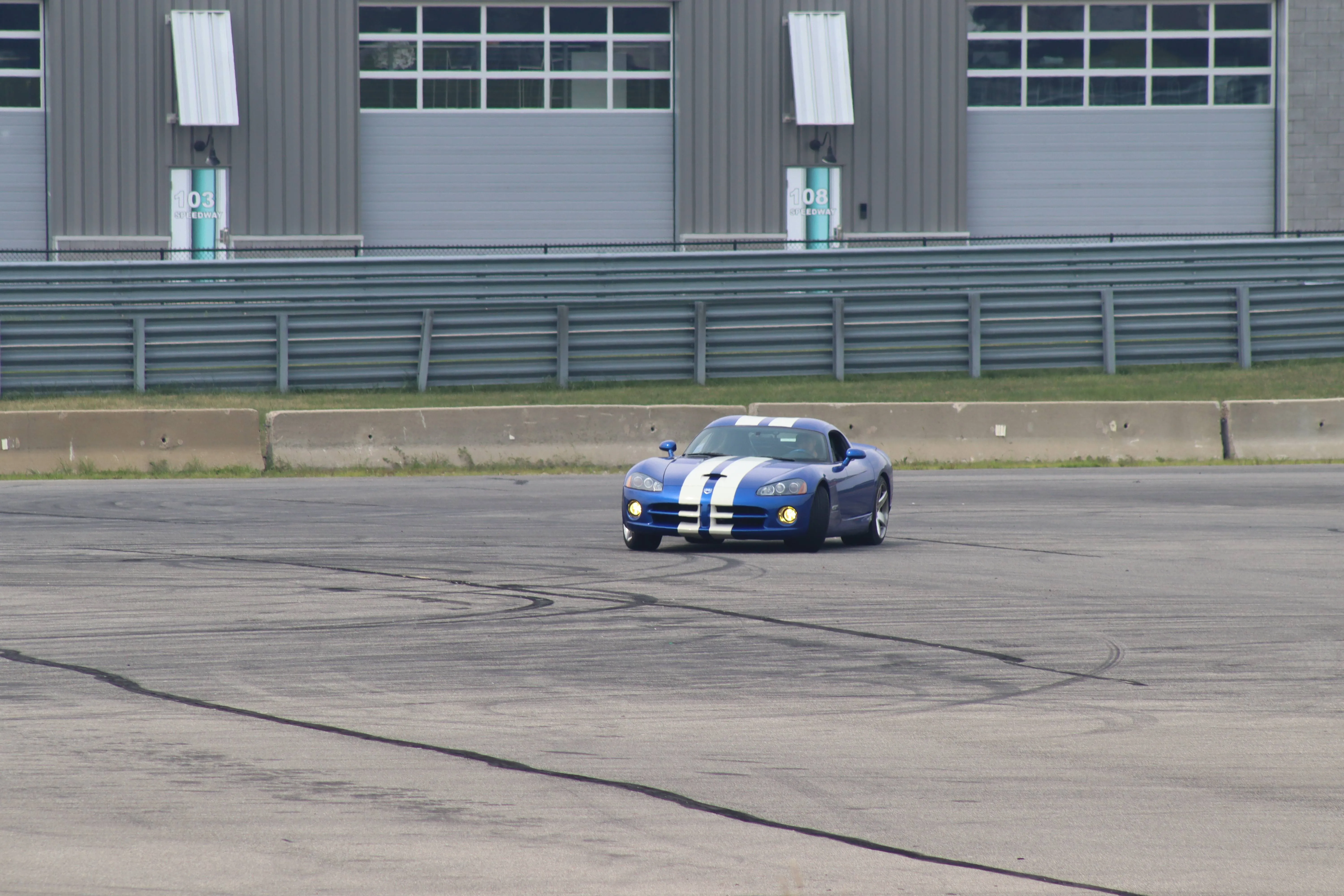 Blue Dodge Viper with white racing stripes on M1 Concourse Arena skid pad