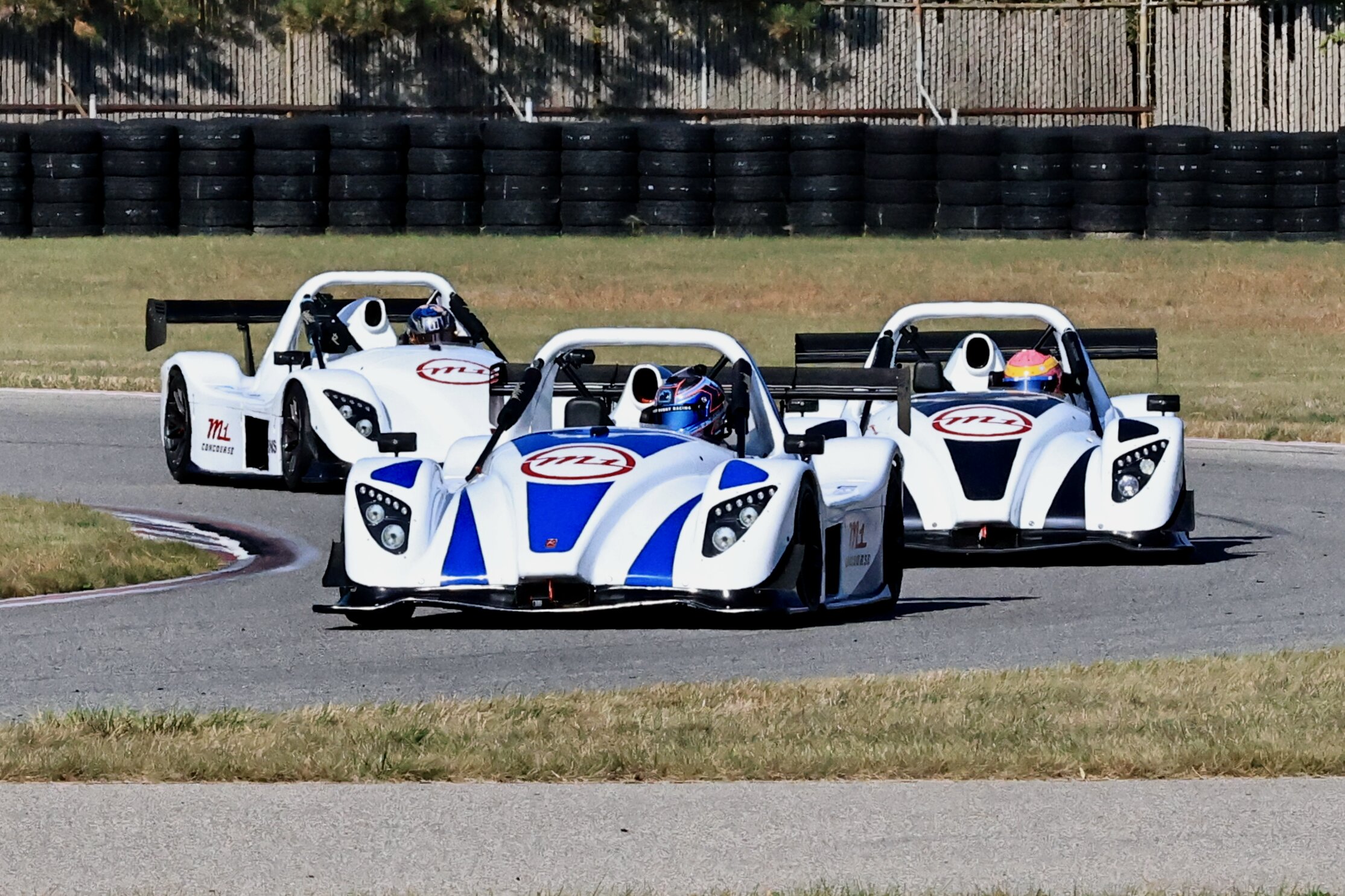 Radical race car driving on track.