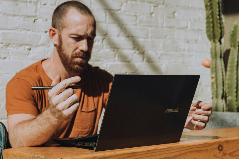 a man sitting at a table using a laptop computer learning how to find grants for nonprofits