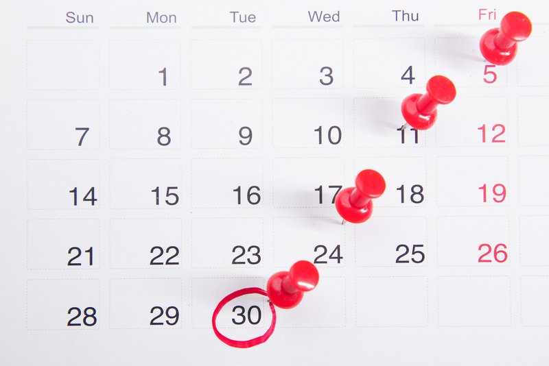 a series of red push pins in a calendar demonstrating capacity planning for a grant calendar template