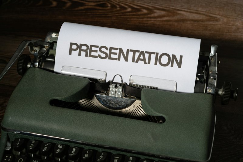 a typewriter with a document that says &quot;presentation&quot; symbolizing a grant proposal cover letter