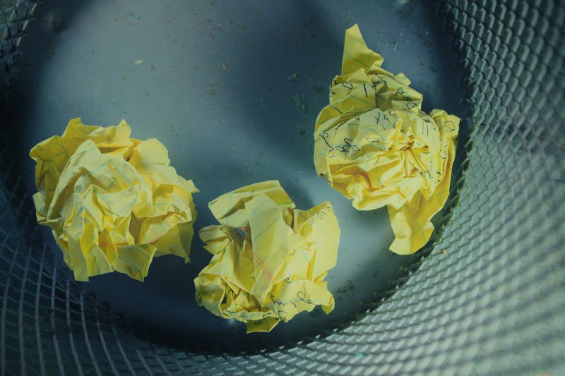 three yellow crumbled grant budget template inside gray trash bin