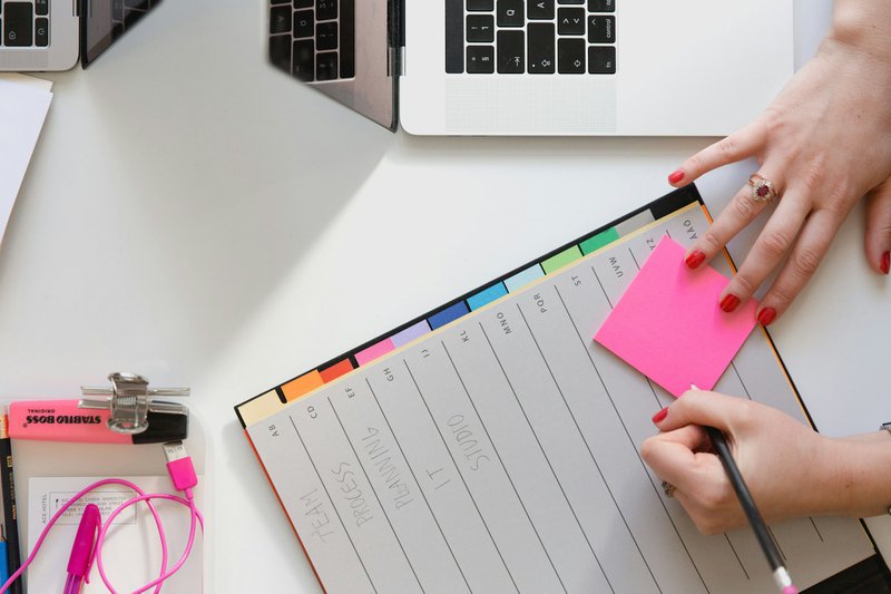 a woman initializing her grant tracking system with a calendar book and laptop on her desk