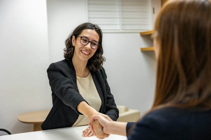 a woman executive director shaking hands with another woman while building grant funder relationships