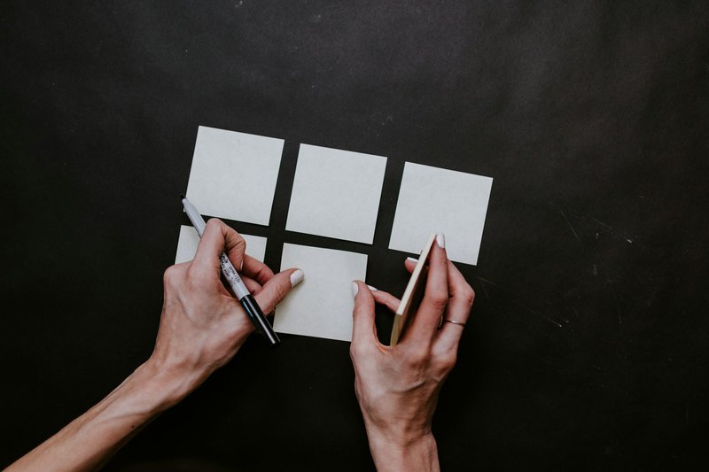 white squares of paper on black background represent the steps in a grant funding process