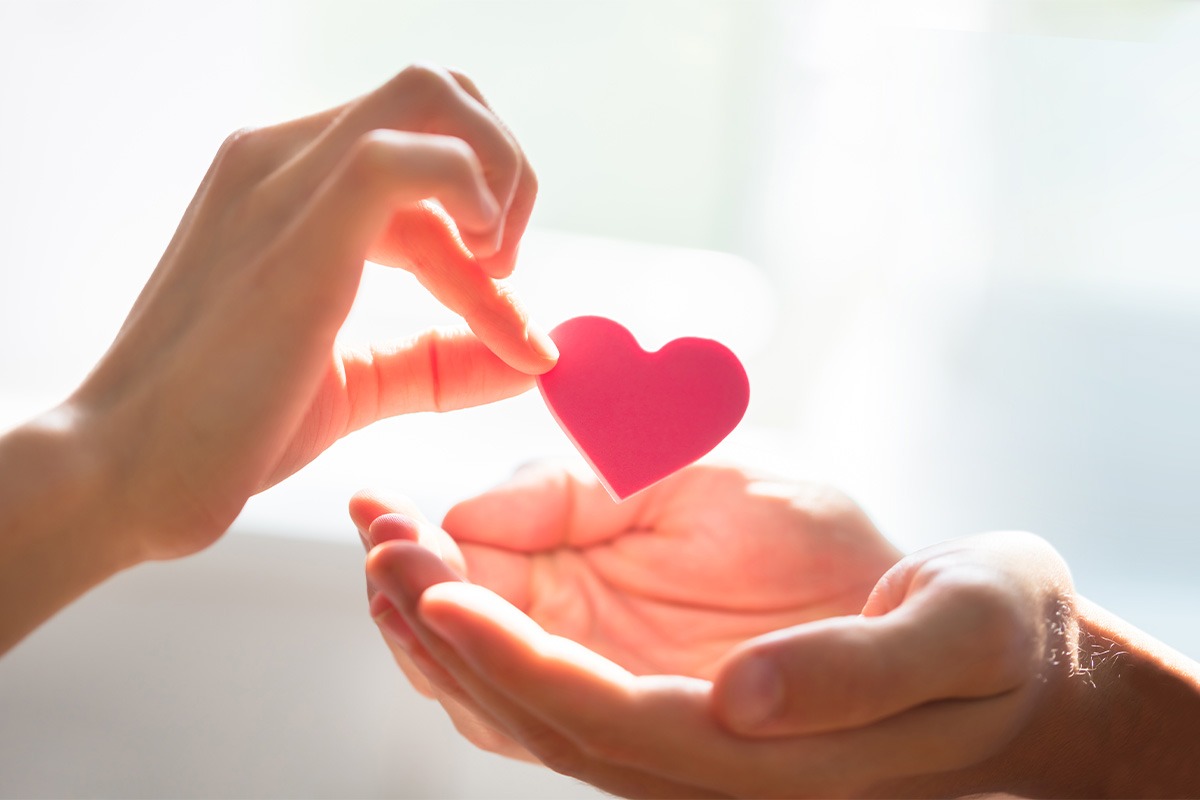 A hand giving a heart to another