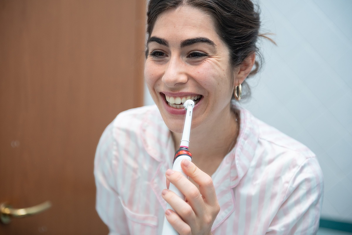 Woman using electric toothbrush