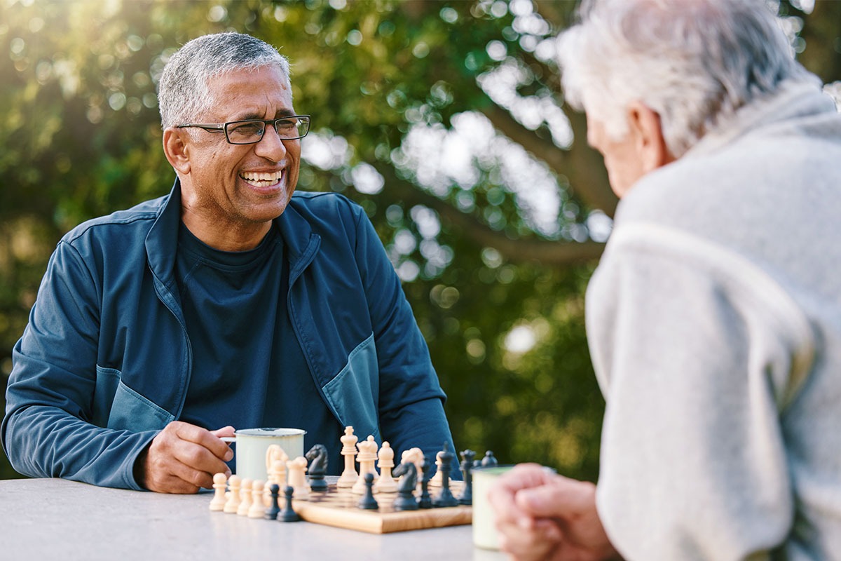 Men playing chess together in a park