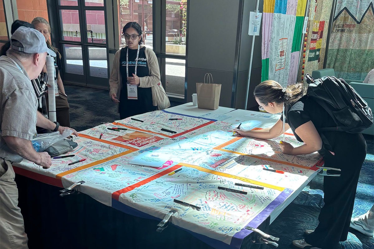 Attendees drawing and writing messages on the WPC 2026 quilt