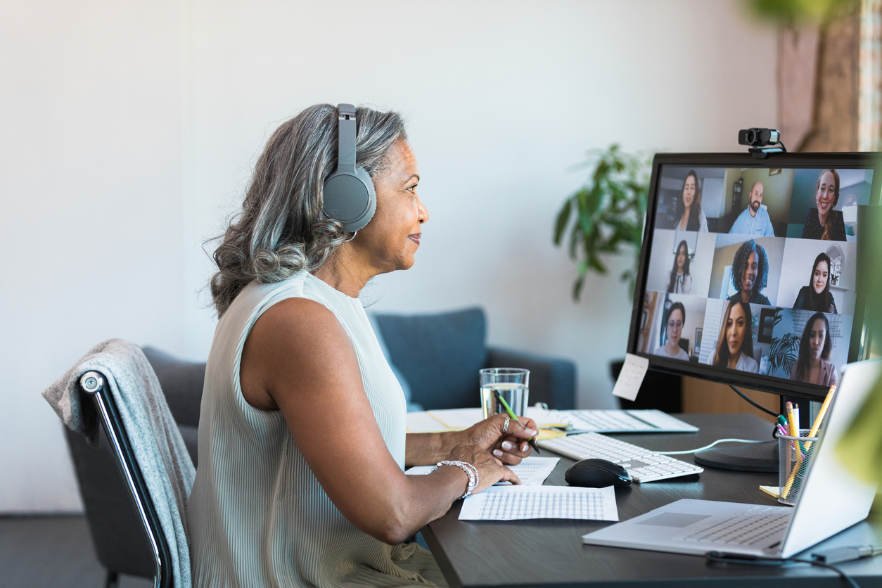Businesswoman attending an online meeting on her laptop at a modern desk
