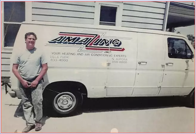 Heating and air conditioning technician standing next to company van