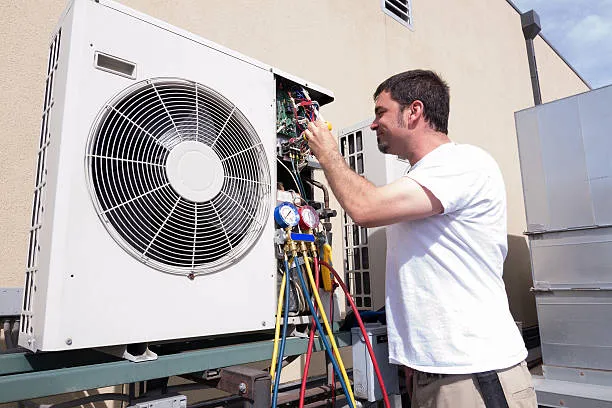 HVAC technician checking and repairing an air conditioning unit outside