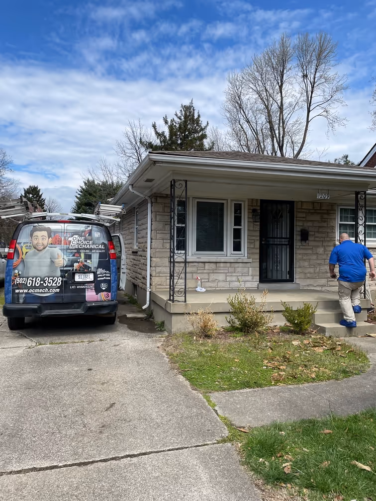 Mechanical service van parked in front of a stone house on a sunny day