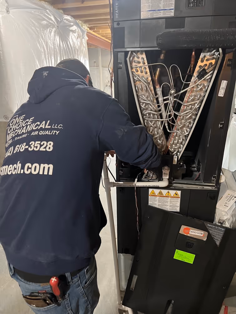HVAC technician inspecting equipment in mechanical room with tools