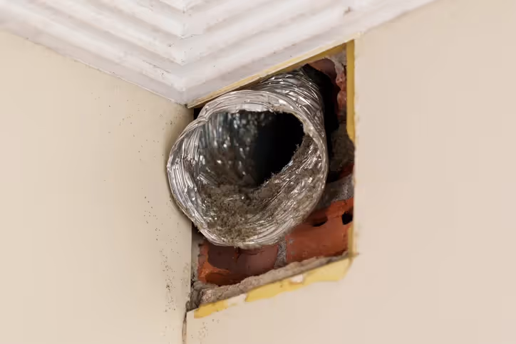 Flexible dryer vent duct connected to wall opening with exposed brick
