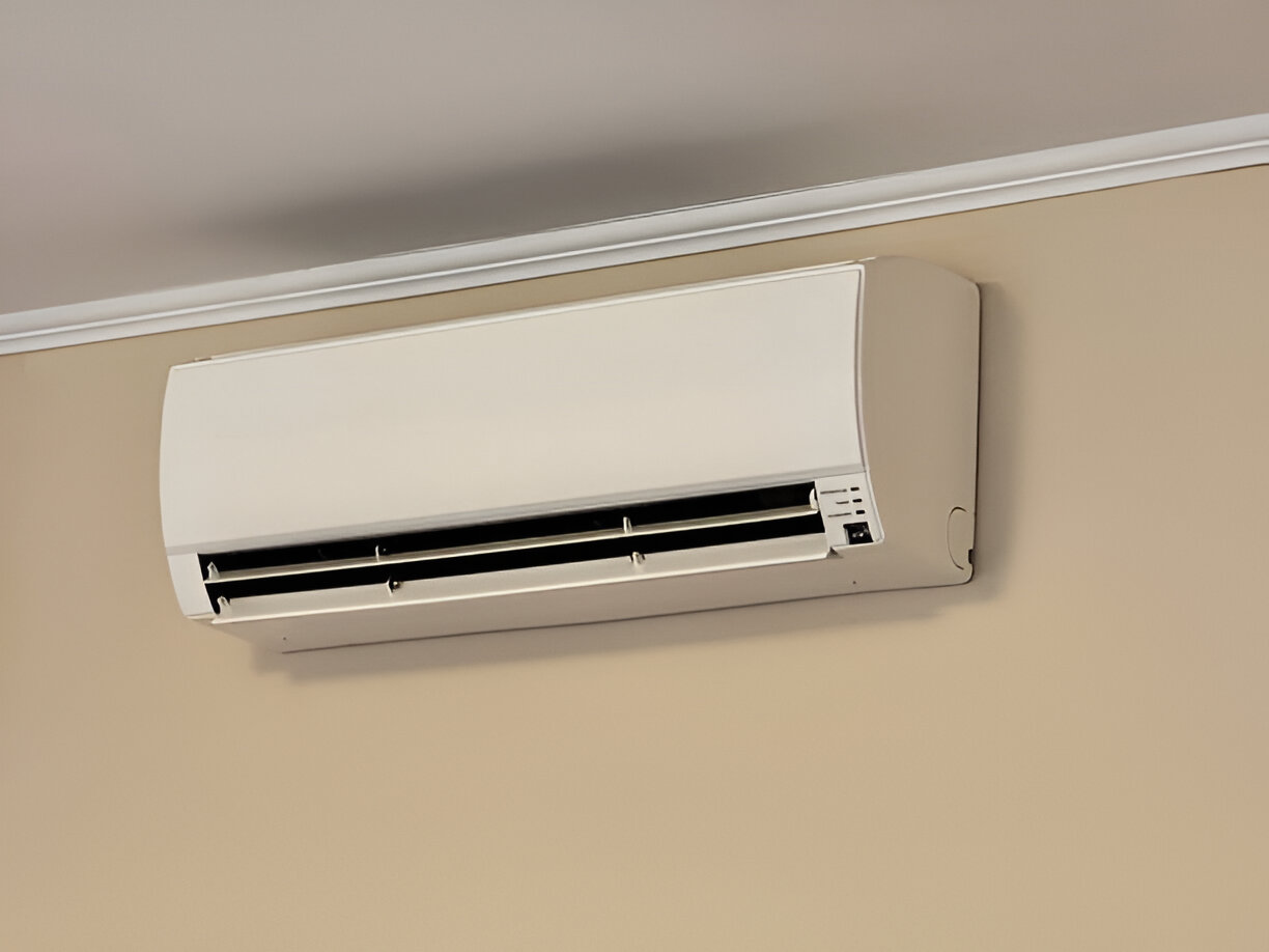 White wall-mounted air conditioning unit with vents and control panel