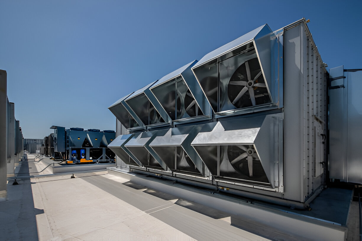 Large industrial cooling system with multiple fans on building rooftop
