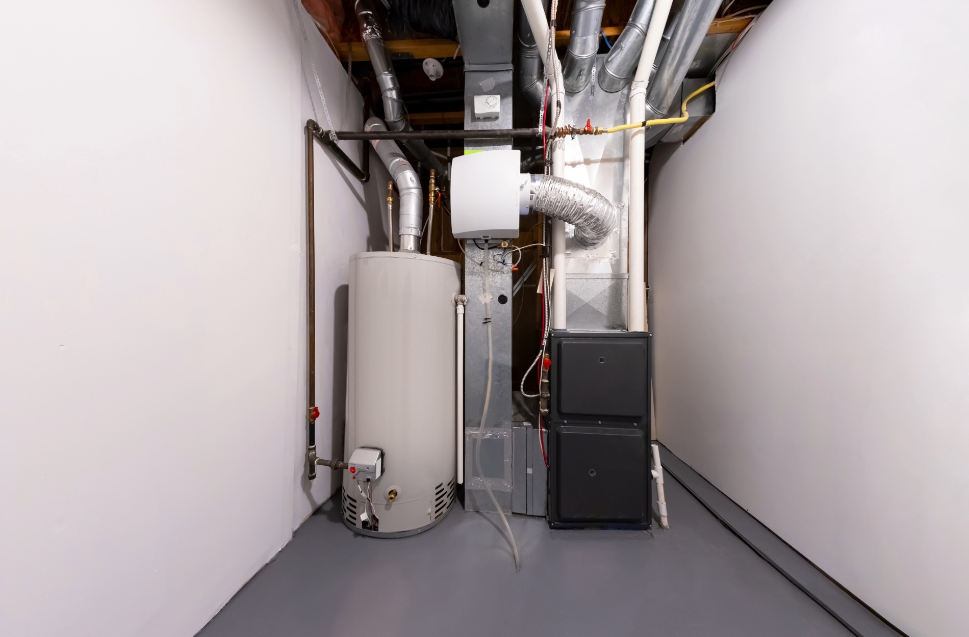 Utility room with water heater, furnace, and exposed pipes and ductwork