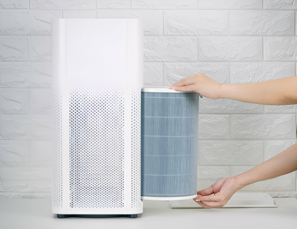 White air purifier with removable blue filter against brick wall