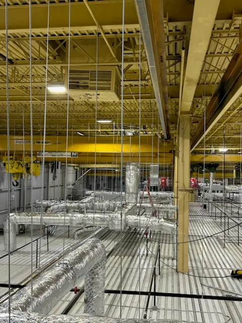 Industrial warehouse with yellow ceiling and metallic ductwork and pipes