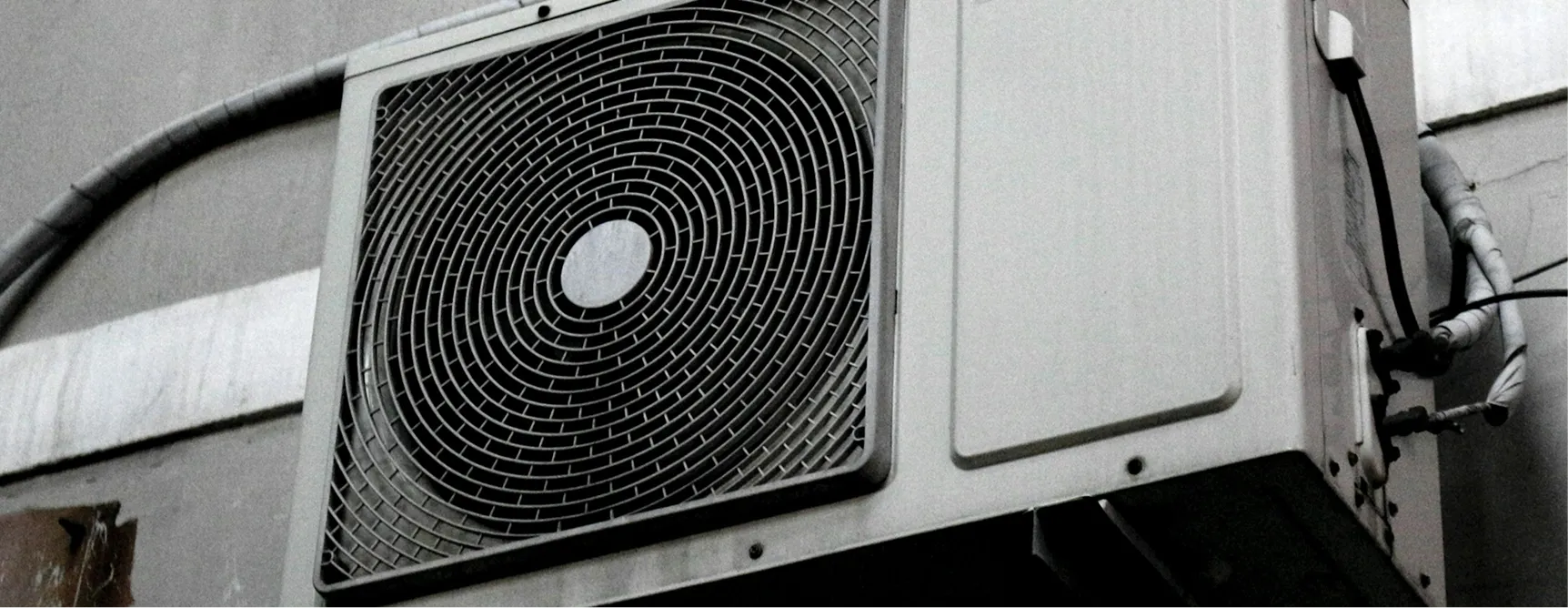 Outdoor air conditioning unit with circular metal grid exhaust fan
