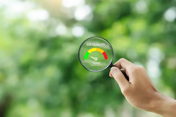 Hand holding air quality meter showing good environmental status
