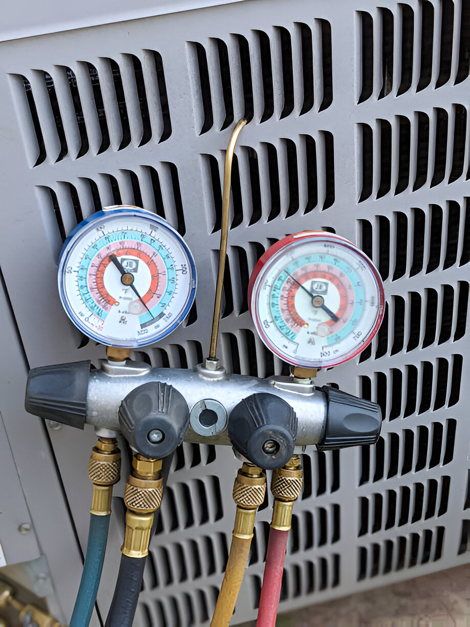 HVAC manifold gauge set with blue, yellow, and red hoses