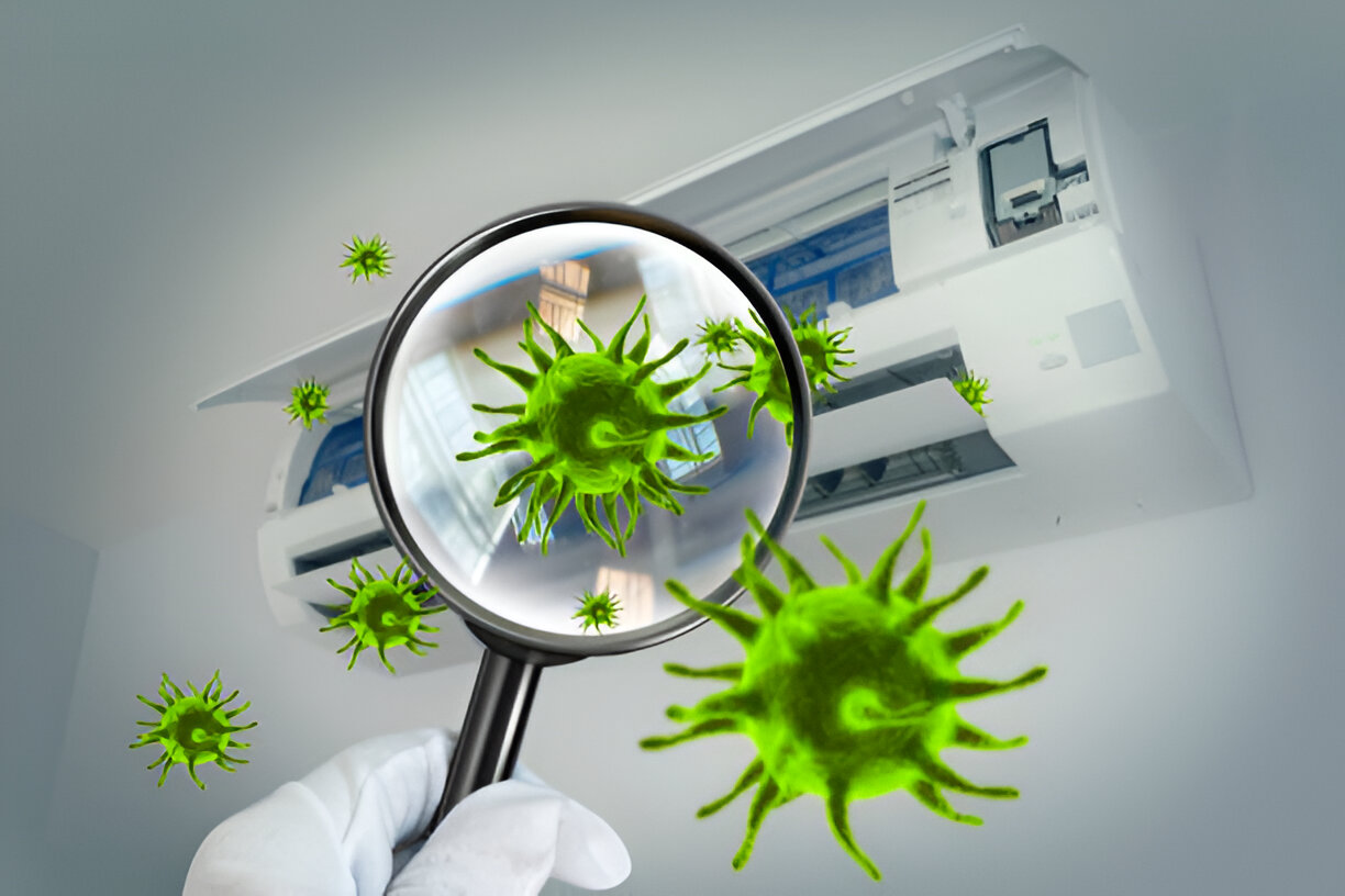 Magnifying glass examining green coronavirus particles near air conditioning unit