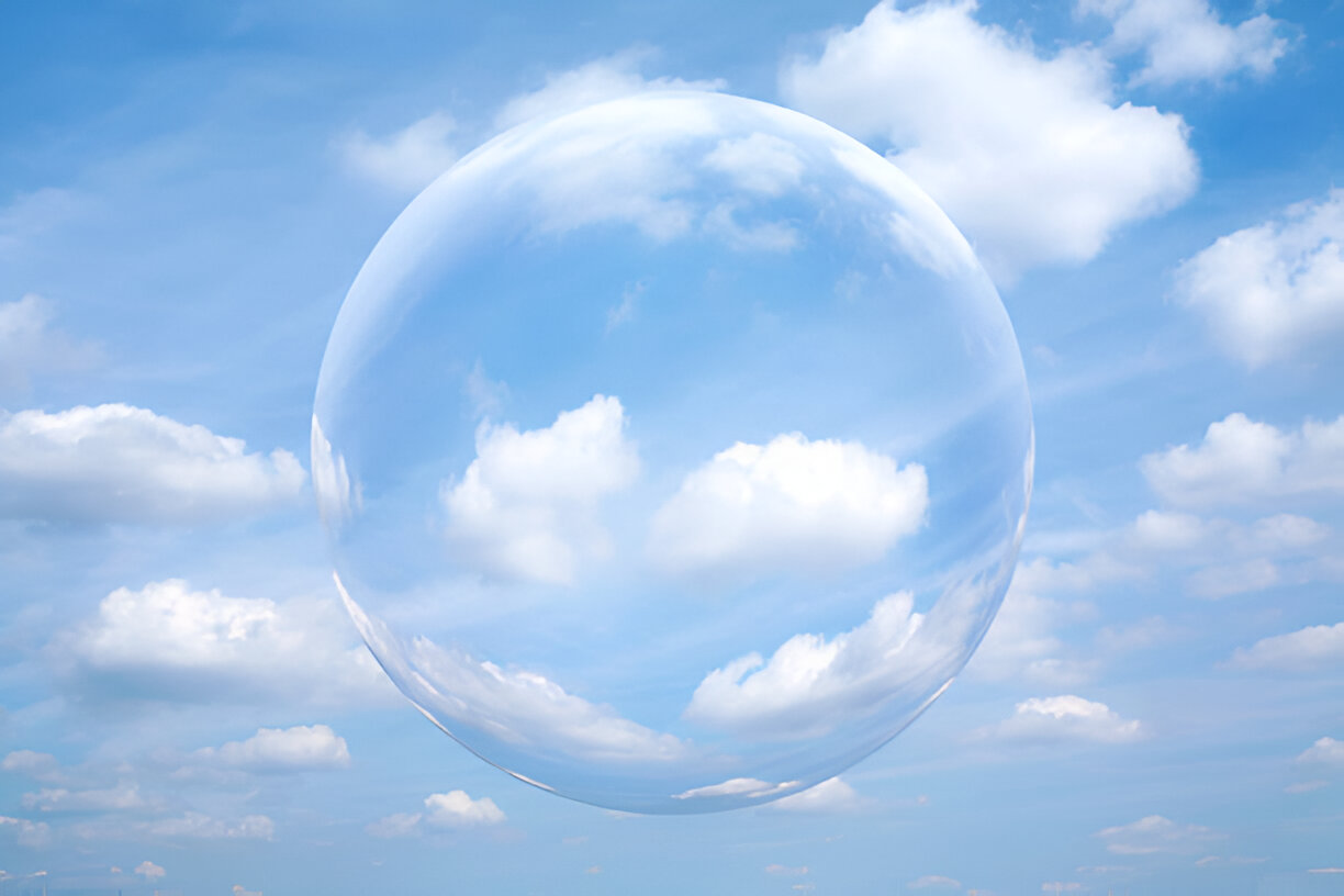 Transparent glass sphere floating among fluffy clouds in blue sky