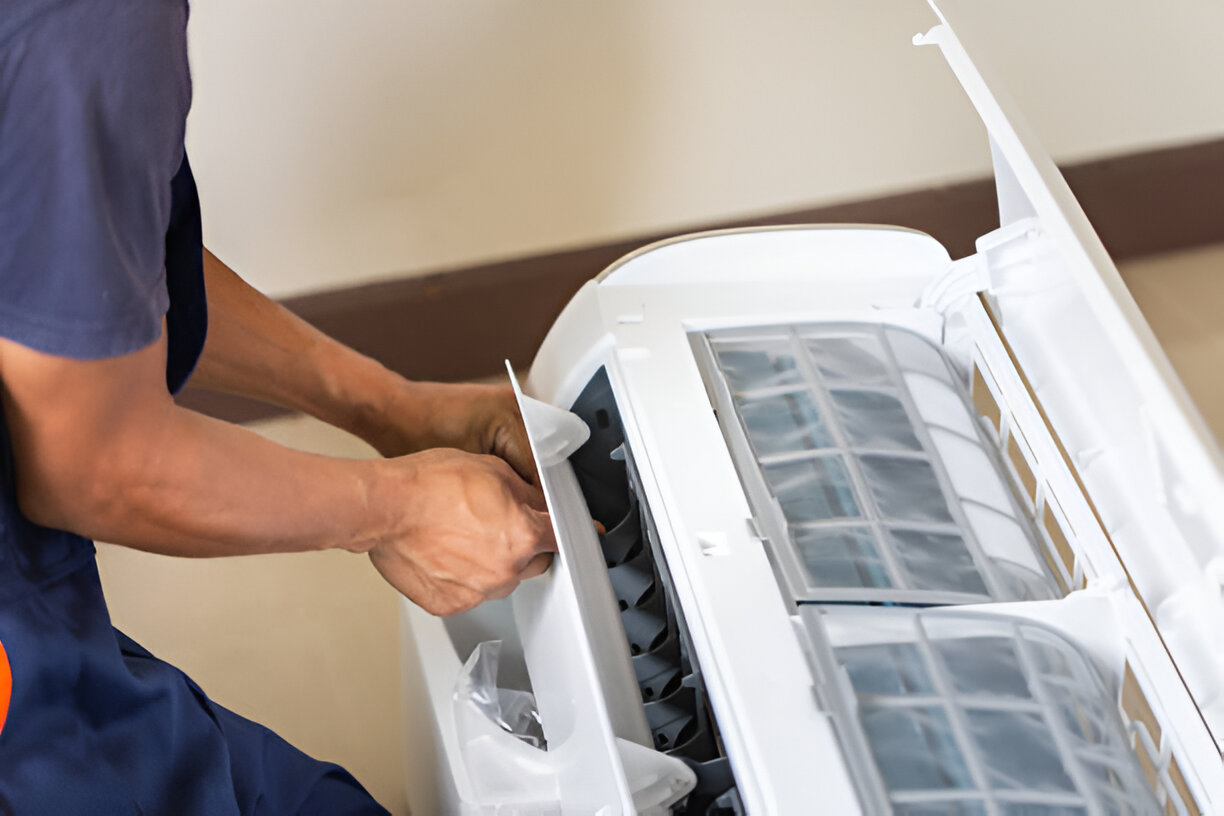 Person cleaning or maintaining air conditioning unit filter