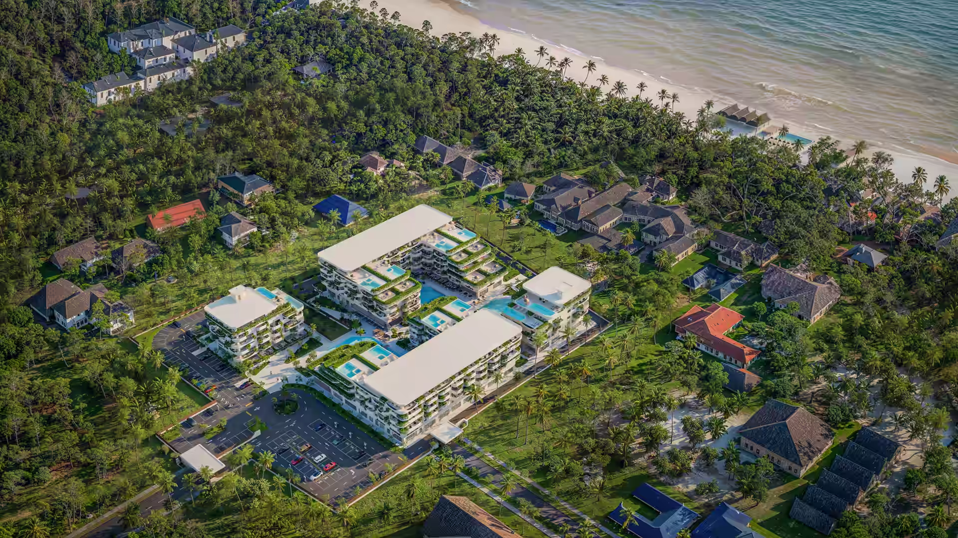 Aerial view of a modern resort with pools, helipads, and villas near a tropical beach.